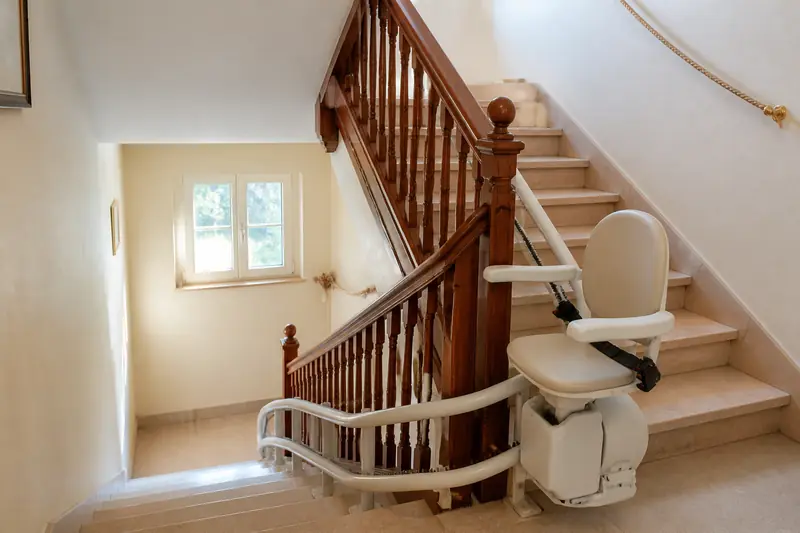 Monte-escalier tournant suivant les deux volées d'un escalier intérieur avec palier